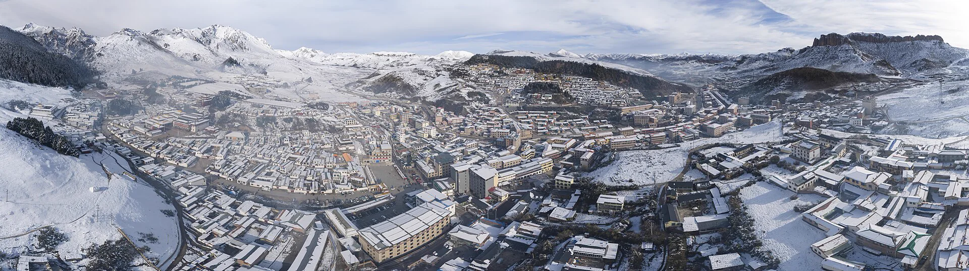 雪后的郎木寺镇、寺院和山谷全景